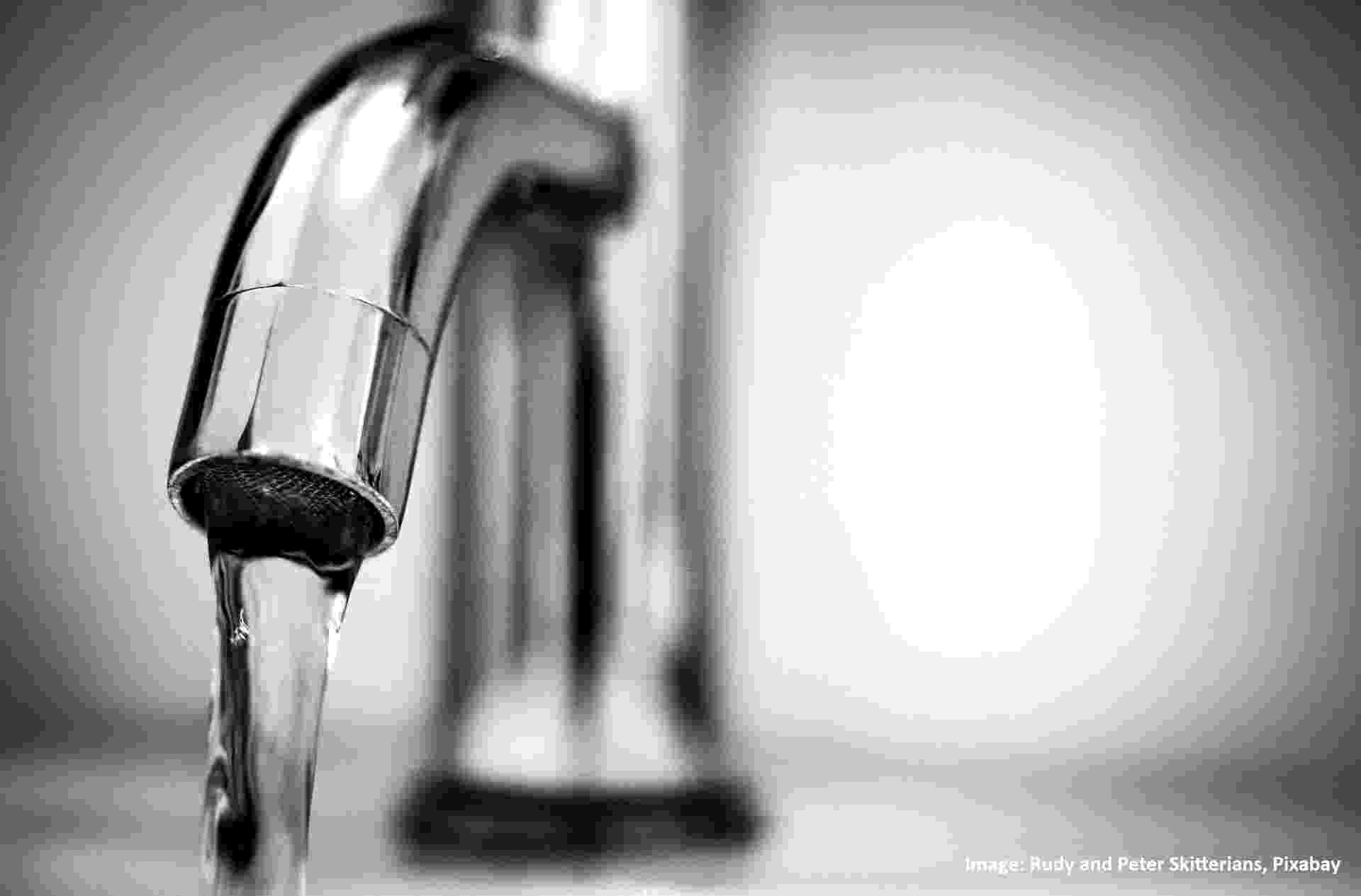 Close-up of a stainless steel tap from which clean water is flowing